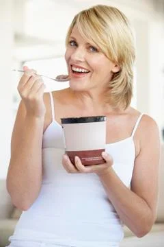 Mid Adult Woman Eating Chocolate Ice-Cream And Smiling At The Camera Stock Photos