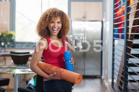 Mid Adult Woman In Holding Yoga Mat And Water Bottle, Portrait