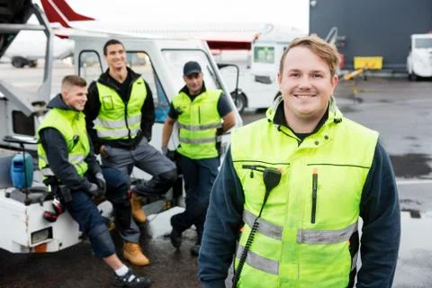 Mid Adult Worker Smiling While Colleagues Resting At Gangway Stock Photos