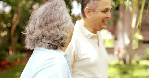 Mid age Indian couple in the park, smiling, chatting Stockbeeldmateriaal 343361483