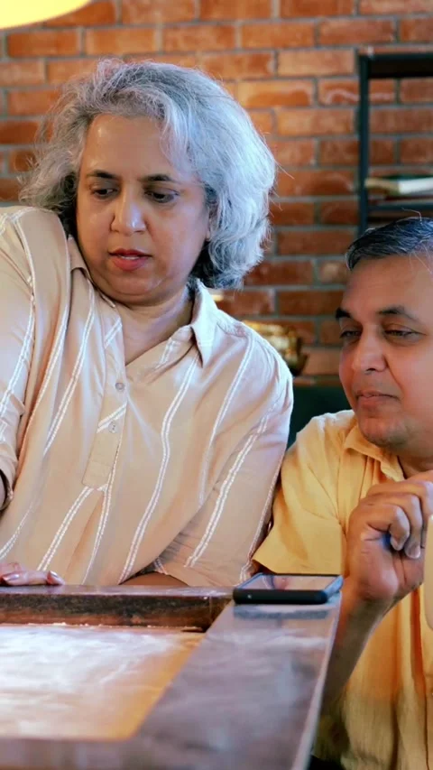 Mid age Indian couple playing carrom board game Stock Footage 343360834