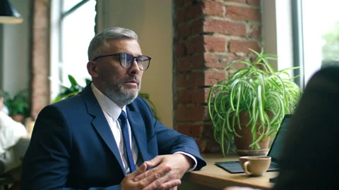 Mid-Aged Businessman Explaining Ideas to Colleague over Coffee at Cafe Stock Footage 315682148