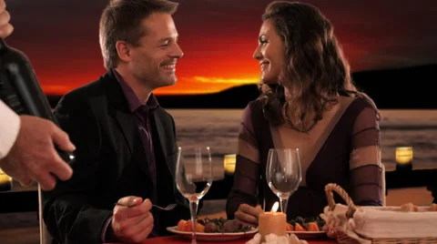 Mid aged couple at dinner waiter pouring wine Stock Footage 43675911