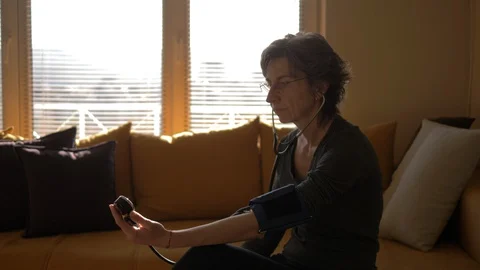 Mid-aged Lady Checking Her Blood Pressure By Herself, Blood Pressure Measurement Video stock 128675010