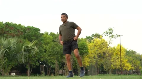 Mid-aged Man doing yoga in a park covered with trees Stock Footage 132085137