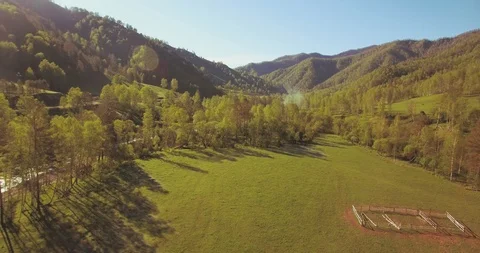 Mid air flight over fresh mountain river and meadow at sunny summer morning Stock Footage 115078634