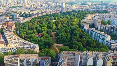 Mid angle panning drone view of Parc des buttes chaumont in Paris cityscape Stock-Footage 341100248