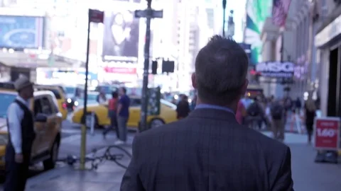 Mid angle view of businessman walking through streets of midtown Manhattan with Stock Footage 83550759
