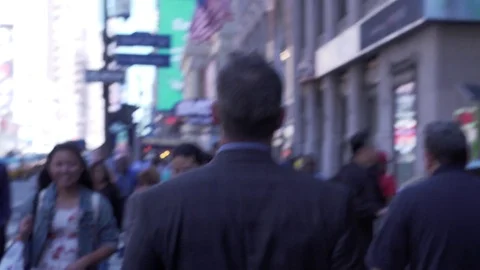 Mid angle view of businessman walking through streets of midtown Manhattan with Stock Footage 83550763