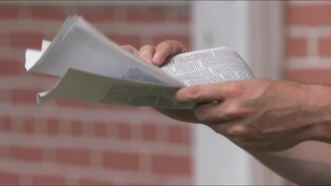 Mid-Century Man stands to read Newspaper near a brick wall Stock Footage 88476517