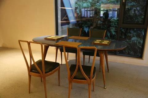 A mid-century modern dining table with four chairs, set in an office enviro.. Stock Photos