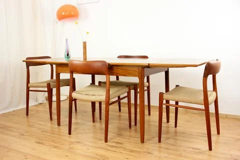 A mid century teak dining table with four chairs from the 50s 60s Danish De.. Stock Photos