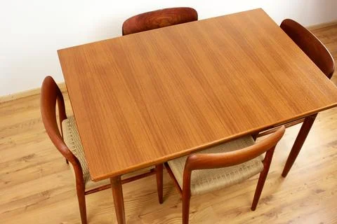 A mid century teak dining table with four chairs from the 50s 60s Danish De.. Stock Photos