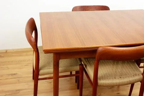 A mid century teak dining table with four chairs from the 50s 60s Danish De.. Stock Photos