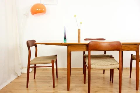 A mid century teak dining table with four chairs from the 50s 60s Danish De.. Stock Photos