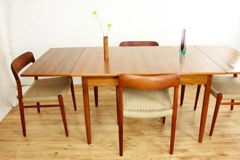 A mid century teak dining table with four chairs from the 50s 60s Danish De.. Stock Photos
