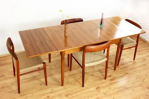 A mid century teak dining table with four chairs from the 50s 60s Danish De.. Stock Photos