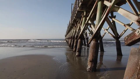 Mid day shoreline beside a wooden pier Stock Footage