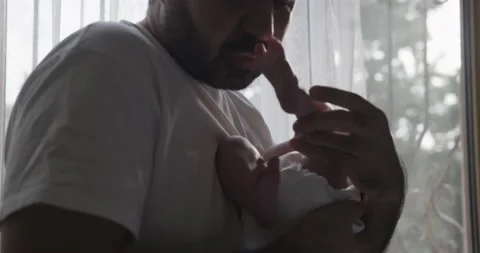 Mid-Eastern Man wearing white t-shirt with baby on hands Stock Footage 221606378