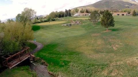 Mid height slow pan over greens to clubhouse front Stock Footage 105606915