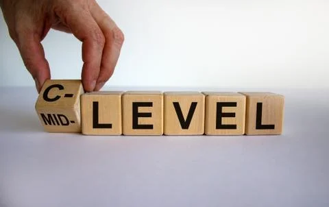 From mid level to C level. Hand turns a cube and changes the words 'mid level Stock Photos