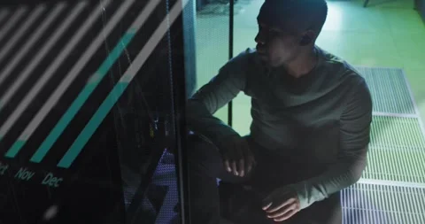 Mid male tech checking data center rack, touching controls and causing holo Stock Footage 330547020