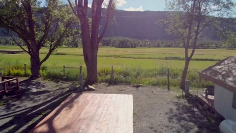 A mid panning drone shot of multiple glamping tents in front of a large Stock Footage 194008110