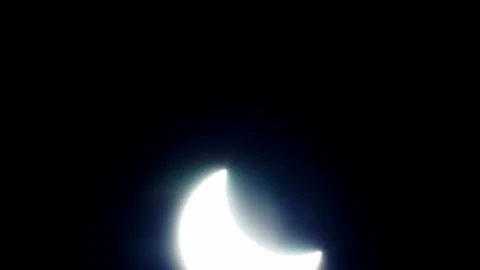 Mid phase solar eclipse .gentle camera tilt from up to down showing the Stock Footage 135710710