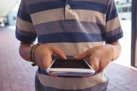 Mid section of boy using mobile phone 스톡 사진