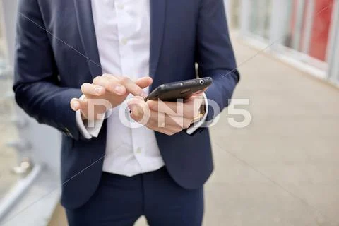Mid Section Of Businessman On Footbridge Texting On Smartphone, London, Uk