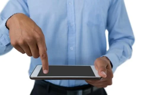 Mid section of businessman pointing on tablet computer Fotos de archivo