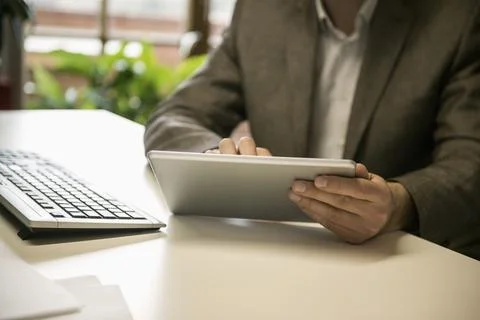 Mid section of a businessman using digital tablet in an office, Bavaria, Germany Stock Photos