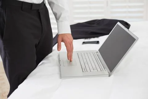 Mid section of businessman using laptop at hotel room Stock Photos