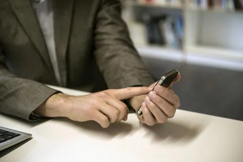 Mid section of a businessman using smart phone in an office, Bavaria, Germany Stock Photos
