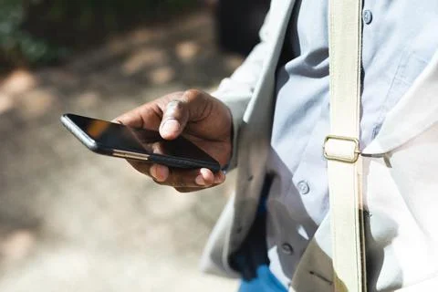 Mid section of businessman using smartphone on the street on the go to office Stock Photos