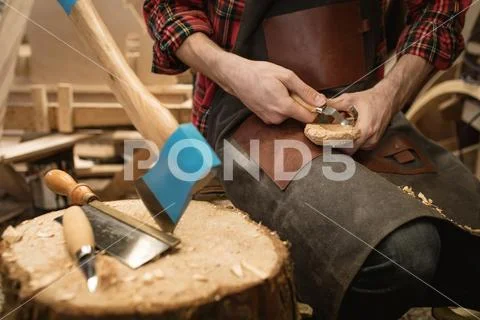 Mid Section Of Carpenter Making Wooden Spoon