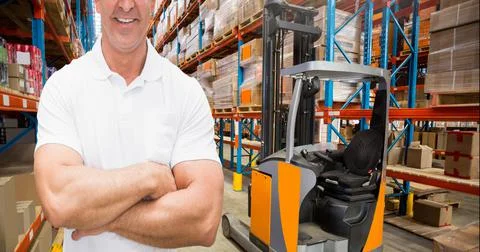 Mid section of caucasian worker arm crossed in an warehouse Stockfoto's