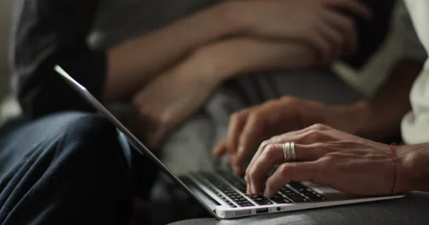 Mid section of couple using a laptop in living room Vídeo Stock 63374139