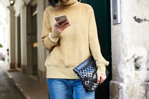 Mid section crop of woman using a smartphone in the street Stock Photos