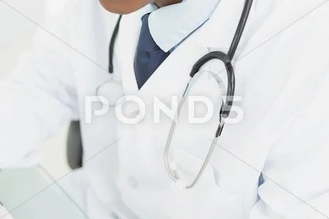 Mid section of doctor in lab coat and with stethoscope Stock Photos