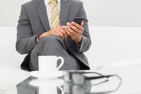 Mid section of an elegant businessman text messaging Stock Photos
