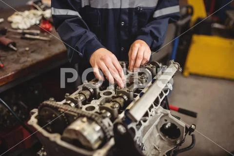Mid-Section Of Female Mechanic Checking A Car Parts