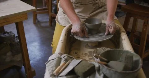 Mid section of female potter using loop tool for finishing pottery at pottery Stockfoto's