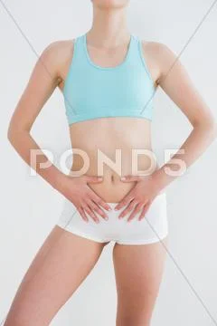 Mid section of a fit woman with hands on belly Stock Photos