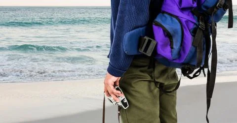 Mid section of man with backpack and digital camera Stock Photos