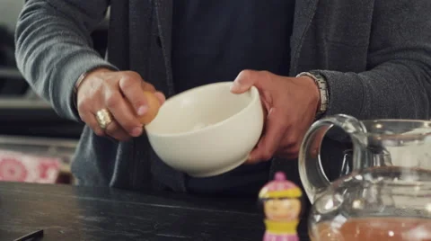 Mid-section of man cracking egg into bowl Stock Footage 63860613