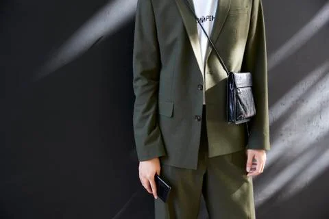 Mid section of a man in dark green suit with black bag Stock Photos