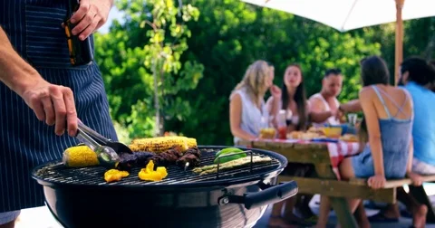 Mid section of man grilling corn, meat and vegetable on barbecue Stock Footage 76239094