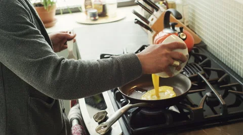 Mid-section of man preparing a scrambled egg in kitchen Stock Footage 63860698