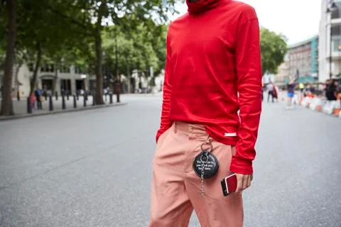 Mid section of man in red polo neck top and pink trousers Stock Photos